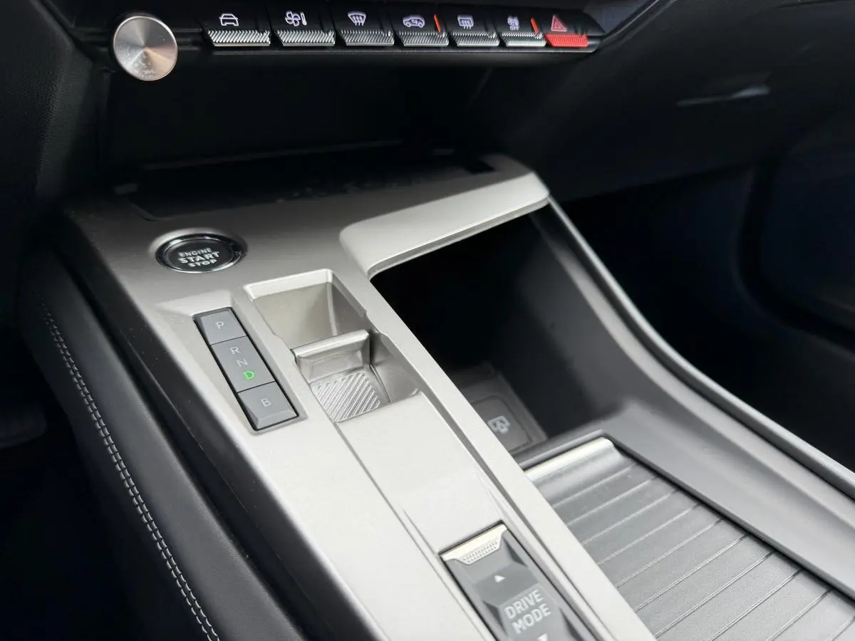Vue rapprochée de la console centrale argentée avec boutons de boîte auto et bouton start dans une Peugeot 308 SW rouge.