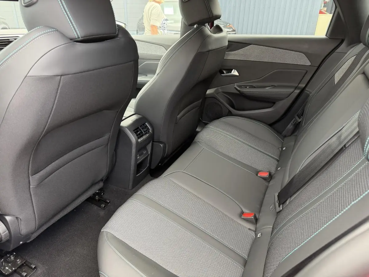 Vue intérieure arrière côté droit de la banquette grise avec surpiqûres bleues et prises USB C sur Peugeot 308 SW 2024.