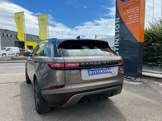 Vue 3/4 arrière d'un Range Rover Velar marron 2018 avec feux arrière LED et toit noir contrastant.