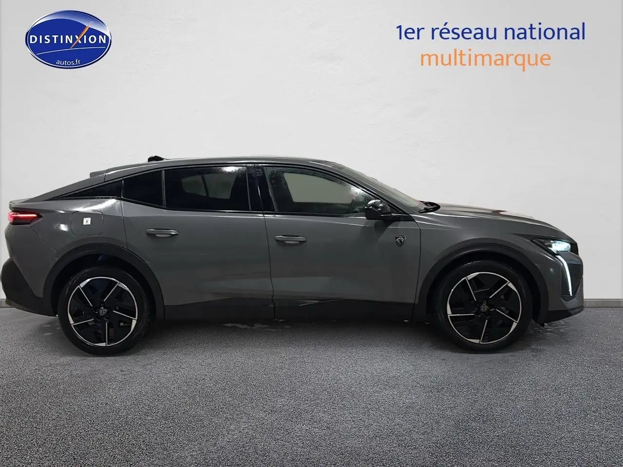 Vue de profil côté gauche d’une Peugeot 408 Hybrid 145 GT gris sélénite avec jantes alliage noires et feux LED allumés.