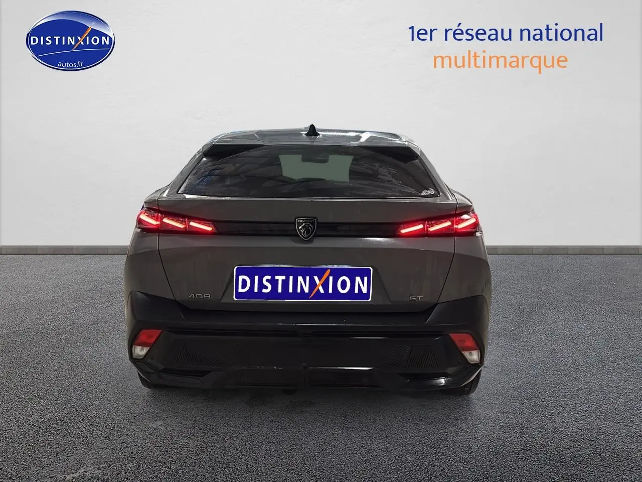 Vue arrière d'une Peugeot 408 Hybrid 145 GT gris sélénite avec feux LED allumés sur fond neutre.