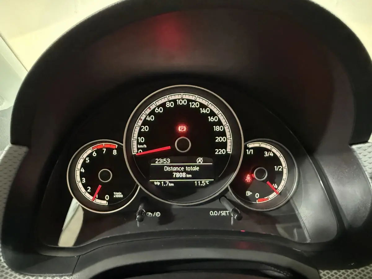 Gros plan sur le tableau de bord noir du Volkswagen Up 1.0 65 Active, affichant vitesse, compte-tours et jauge carburant.