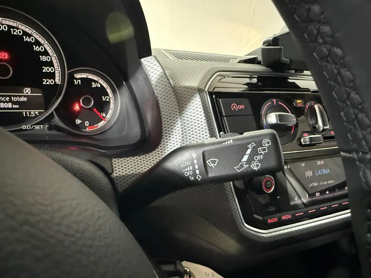 Vue rapprochée de l'intérieur du Volkswagen Up 2022, montrant le tableau de bord gris et la commande d'essuie-glace.