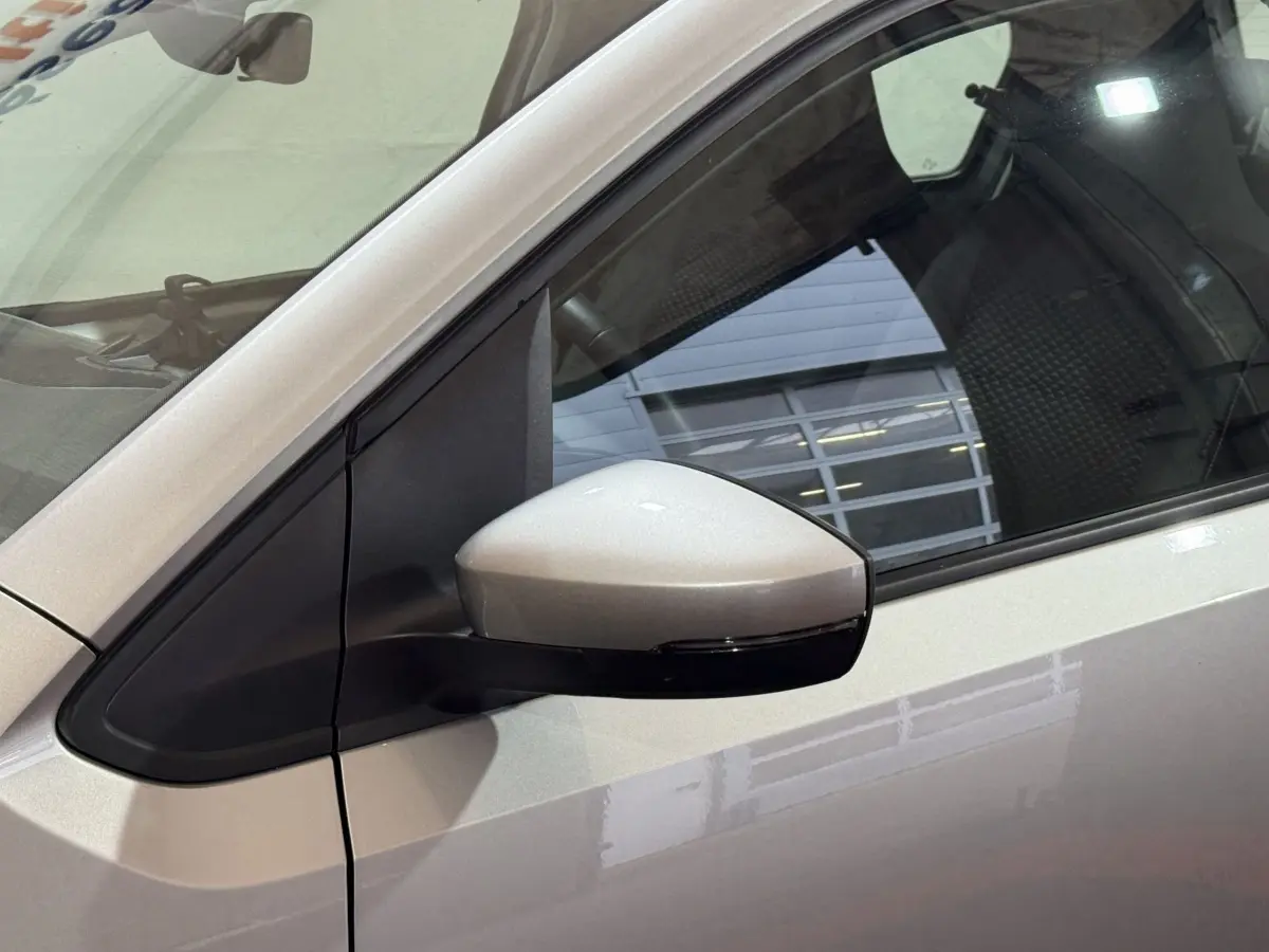 Vue rapprochée du rétroviseur côté gauche d’une Volkswagen Up gris foncé avec caméra intégrée.