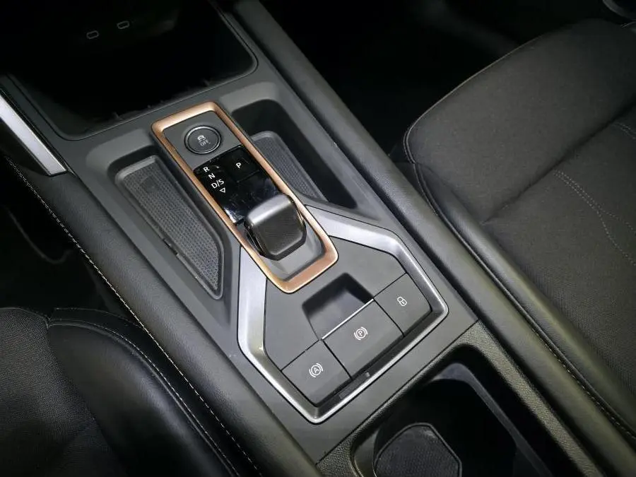 Gros plan sur la console centrale noire du CUPRA Formentor 2025, avec levier de vitesses automatique et finitions cuivrées.