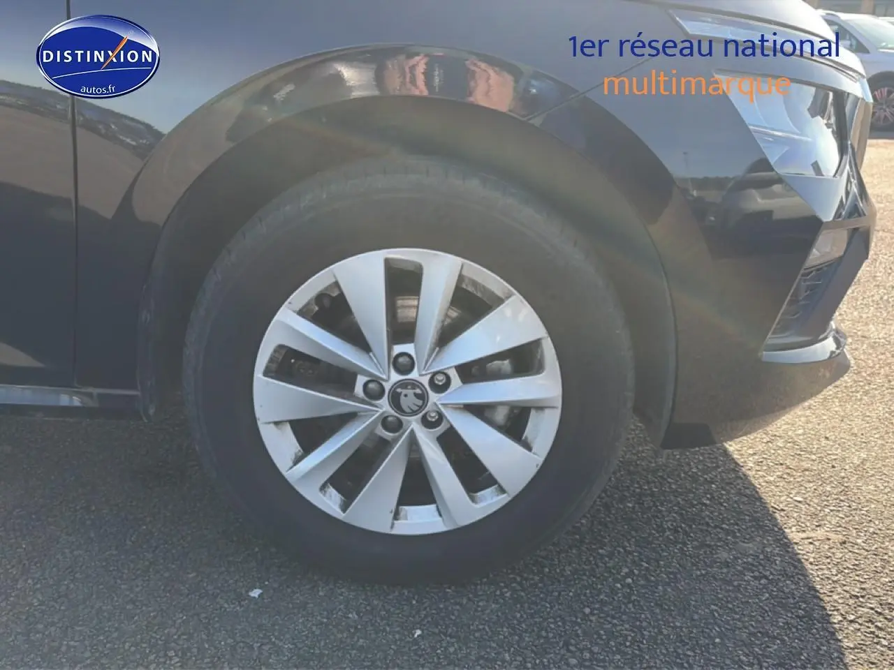 Gros plan sur la roue avant gauche et la jante alu argentée d’un Skoda Kamiq noir, avec partie du pare-chocs avant visible.