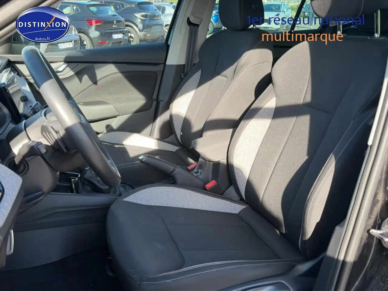 Vue intérieure côté conducteur du Skoda Kamiq noir 2025, mettant en valeur les sièges bi-ton gris et noir et le volant multifonction.