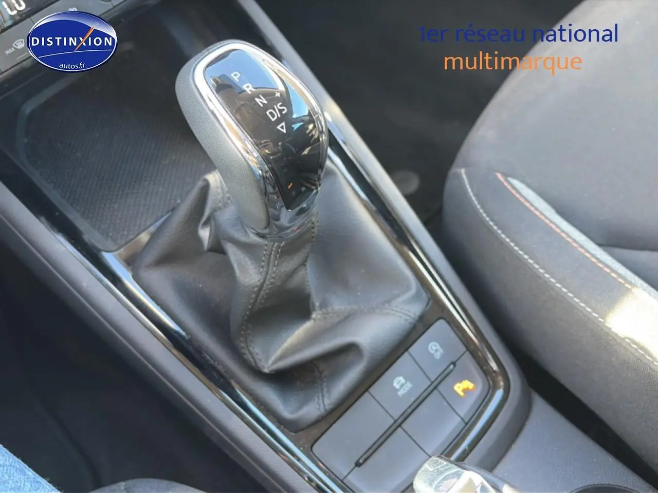 Vue rapprochée du levier de vitesse automatique noir et cuir du Skoda Kamiq 2025, avec siège tissu gris à côté.