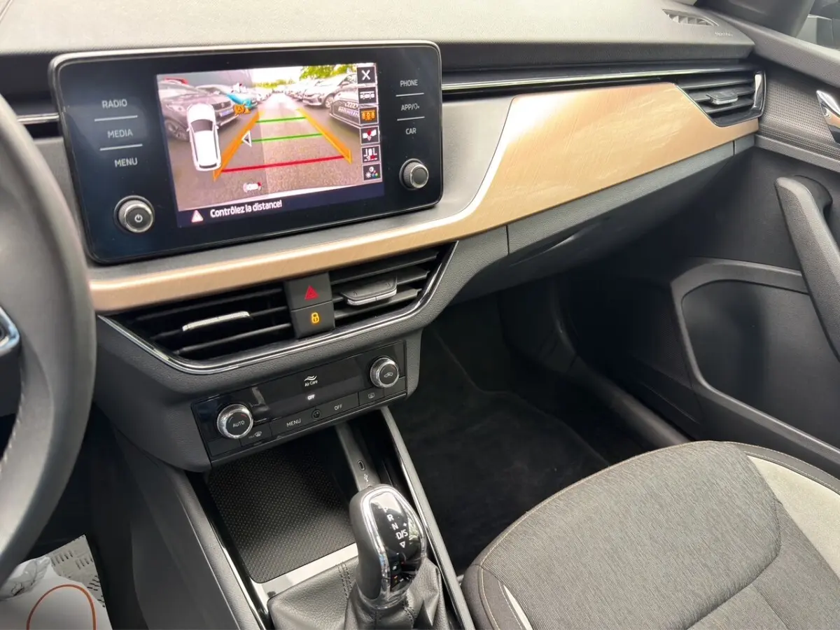 Vue intérieure du tableau de bord et console centrale du Skoda Kamiq 2023 avec écran de recul et levier de boîte automatique.