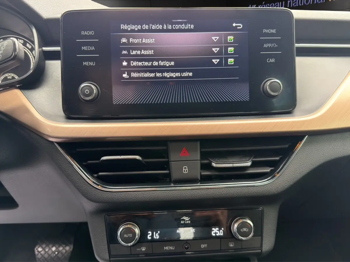 Vue rapprochée du tableau de bord du Skoda Kamiq 2023, écran tactile affichant les aides à la conduite.