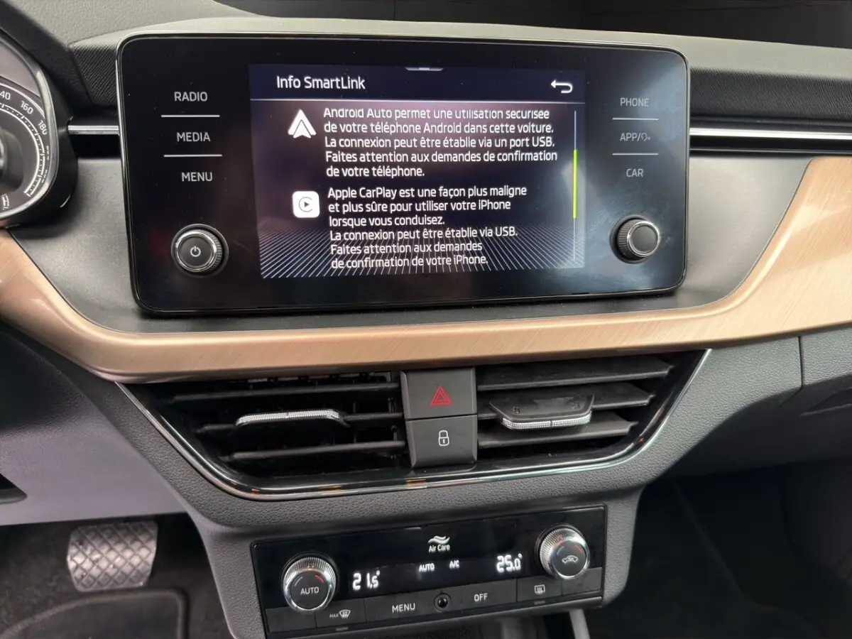 Vue rapprochée de l’écran tactile central et de la console de climatisation du Skoda Kamiq 2023, intérieur noir avec insert bois clair.