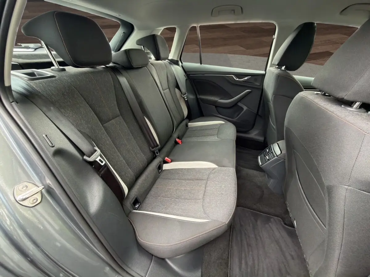 Vue intérieure arrière côté gauche du Skoda Kamiq 2023 gris foncé, montrant la banquette tissu et les portes.