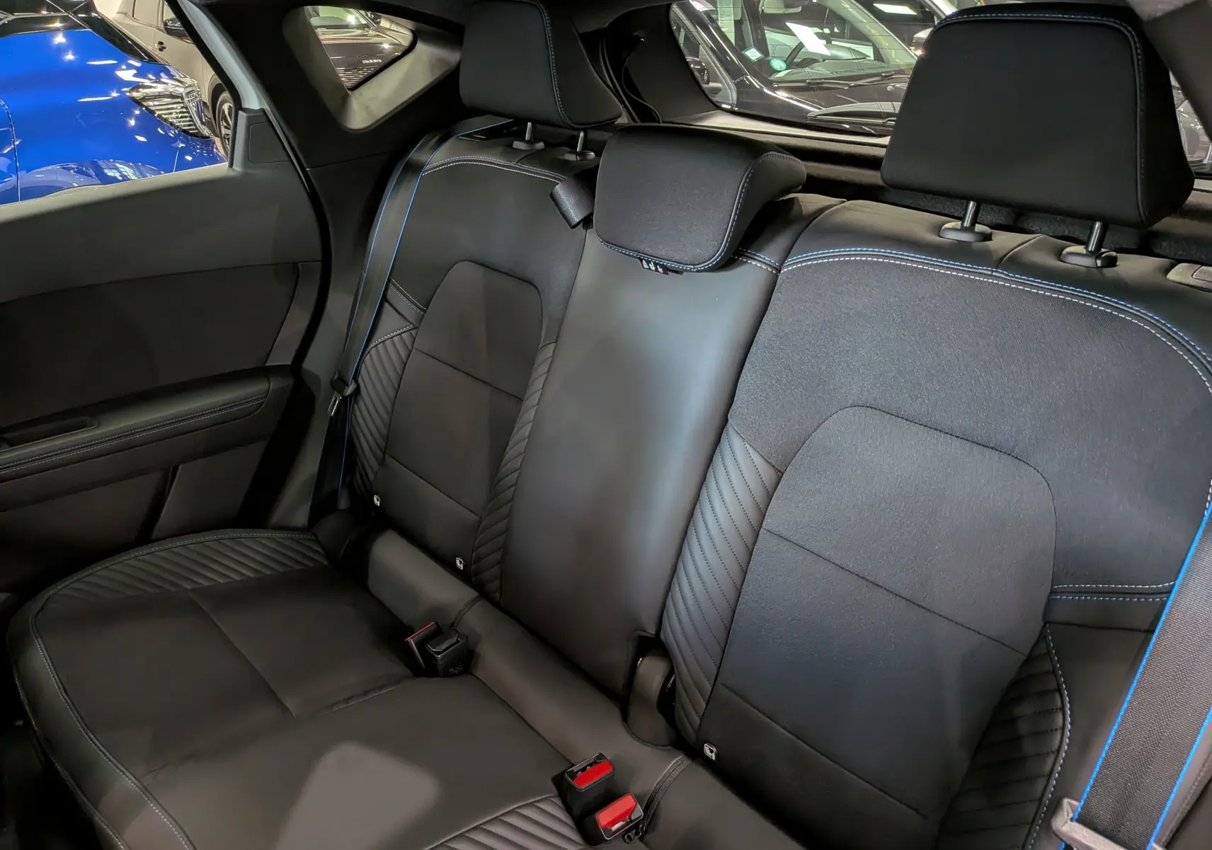 Vue intérieure sur la banquette arrière en cuir noir avec surpiqûres bleues du Renault Captur E-Tech 2026.