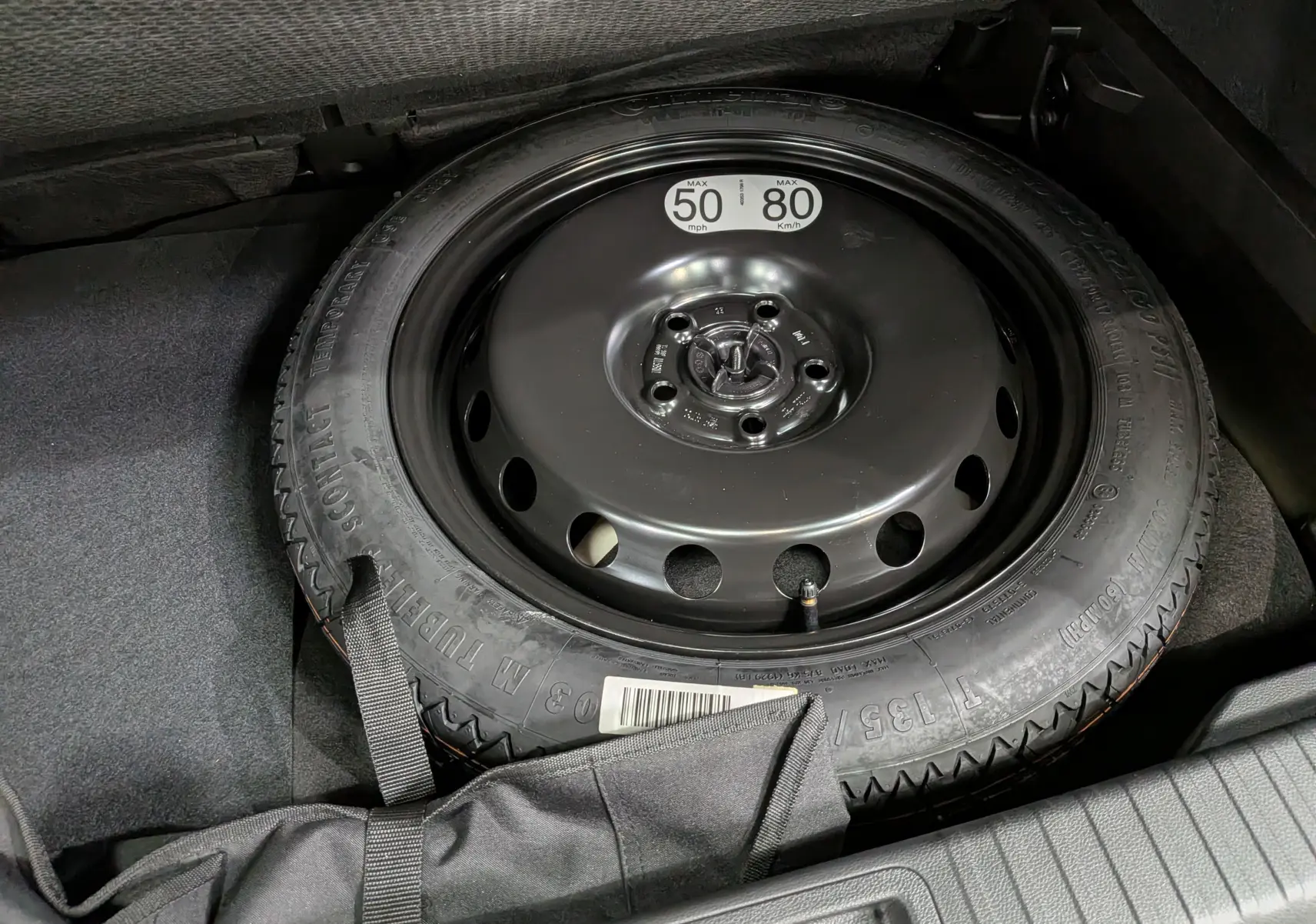 Gros plan sur la roue de secours noire dans le coffre du Renault Captur E-Tech blanc nacré 2026.