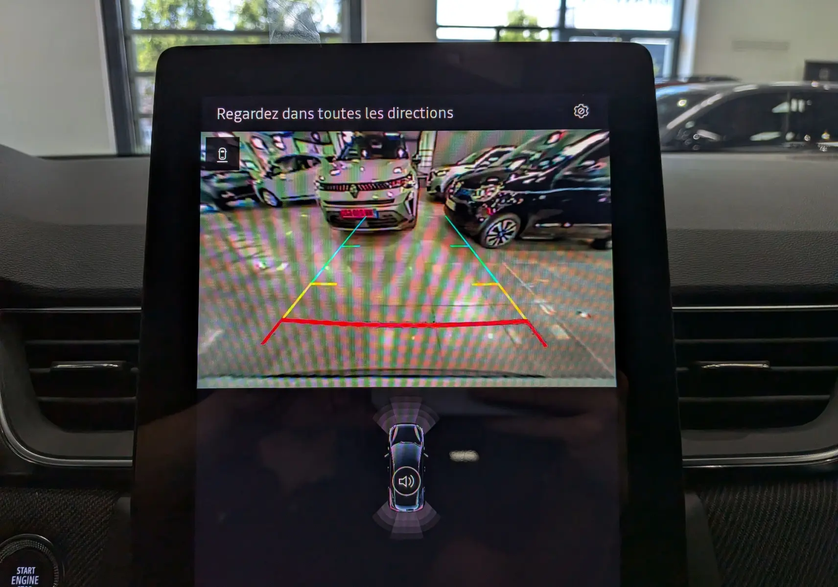 Écran de caméra de recul du Renault Captur E-TECH blanc nacré avec toit noir, affichant l'arrière en intérieur.