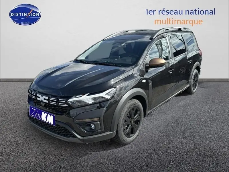 Vue 3/4 avant droite d'un Dacia Jogger 2024 noir nacré métallisé avec barres de toit et jantes noires.