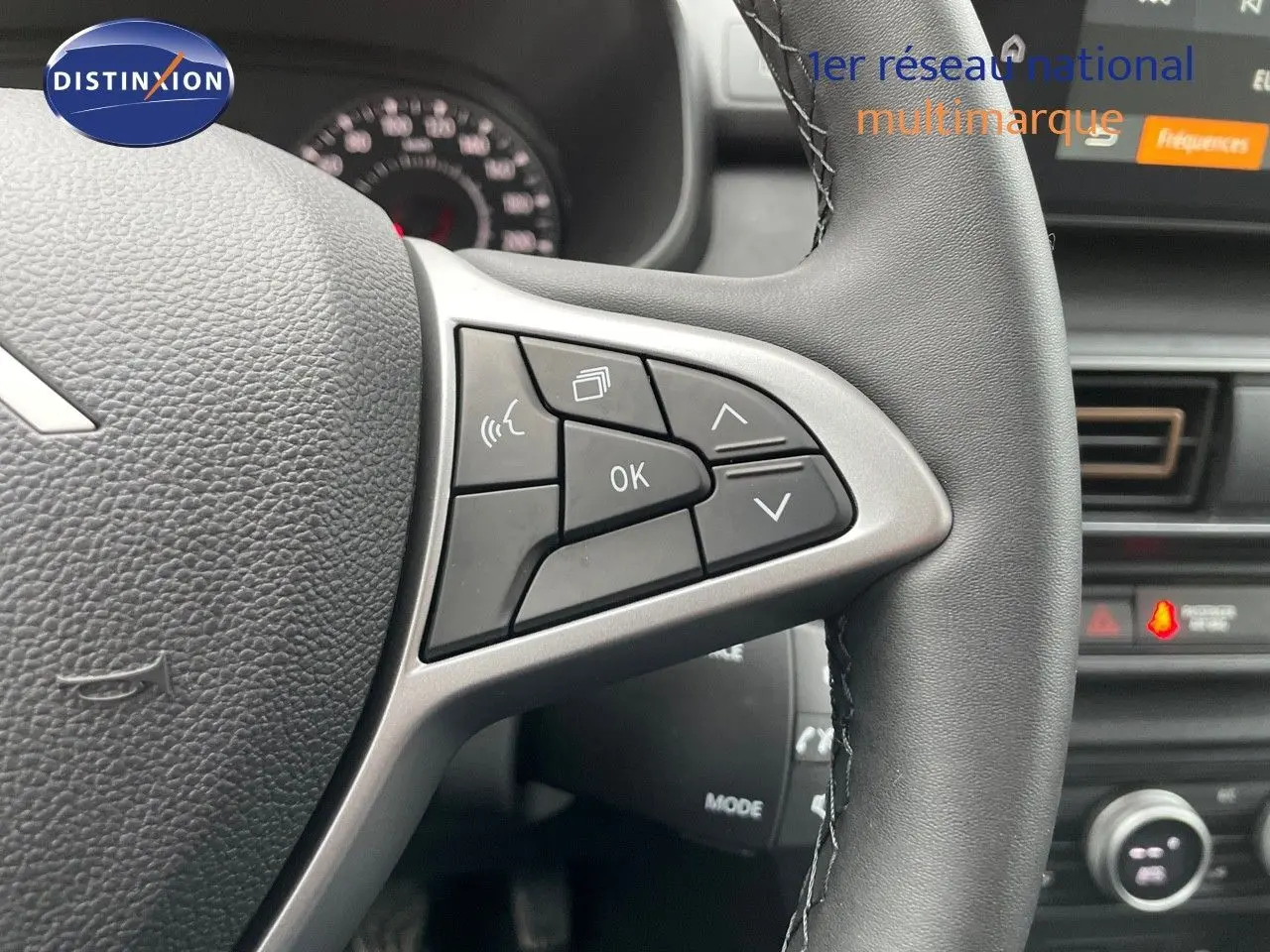 Gros plan sur les commandes au volant en cuir noir du Dacia Jogger 2024, avec écran tactile et tableau de bord partiel visible.