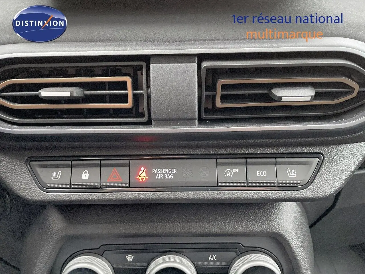 Vue rapprochée du tableau de bord du Dacia Jogger 2024, avec commandes clim et alertes visibles en noir et gris.