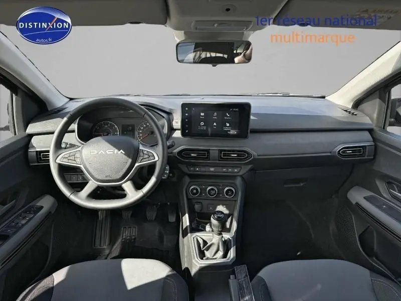 Vue intérieure frontale du tableau de bord et volant noir de la Dacia Jogger 2024 avec écran tactile et boîte manuelle.