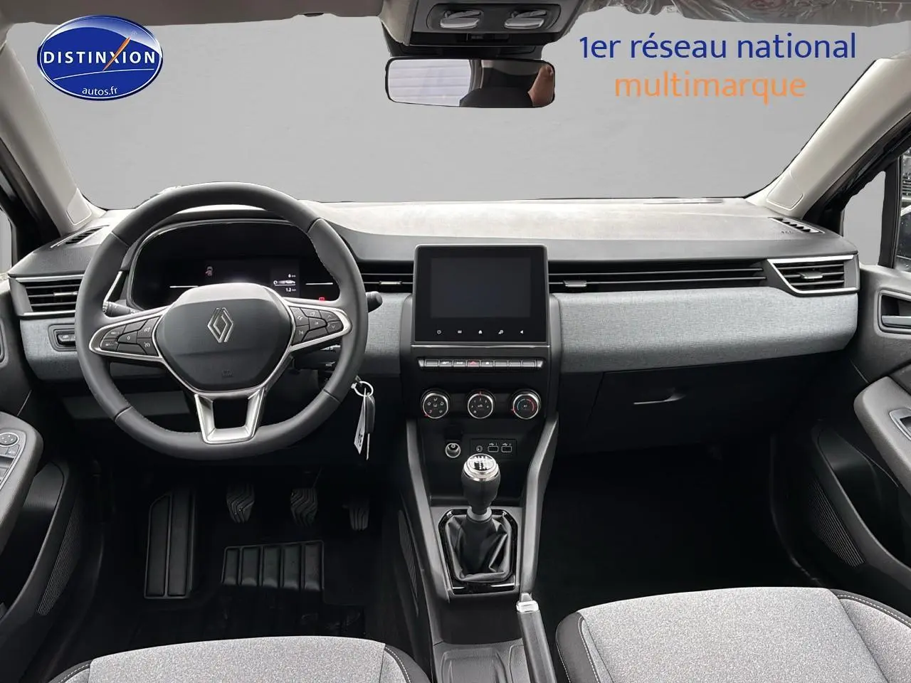 Intérieur avant de la Renault Clio V diesel 2025, volant multifonction, boîte manuelle et écran tactile central.