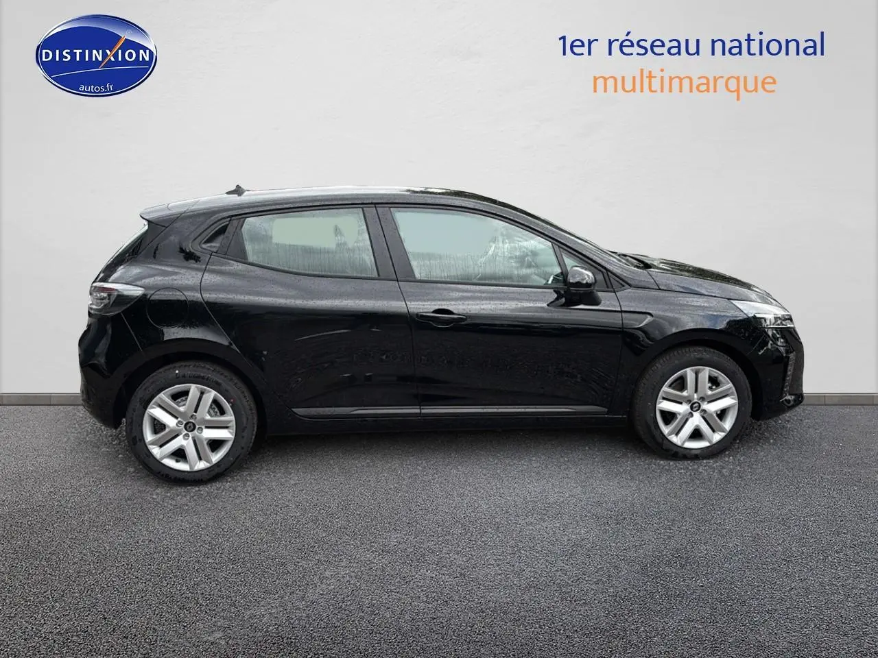 Profil côté gauche d'une Renault Clio V noire 2025, avec jantes argentées et vitres teintées sur fond neutre.