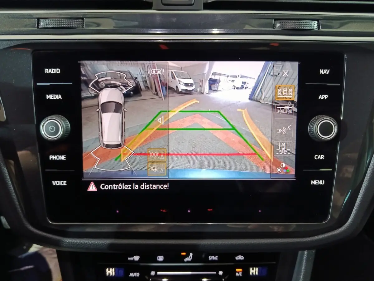 Écran tactile intérieur du Volkswagen Tiguan 2021 montrant la caméra de recul avec guidage dynamique en couleurs.