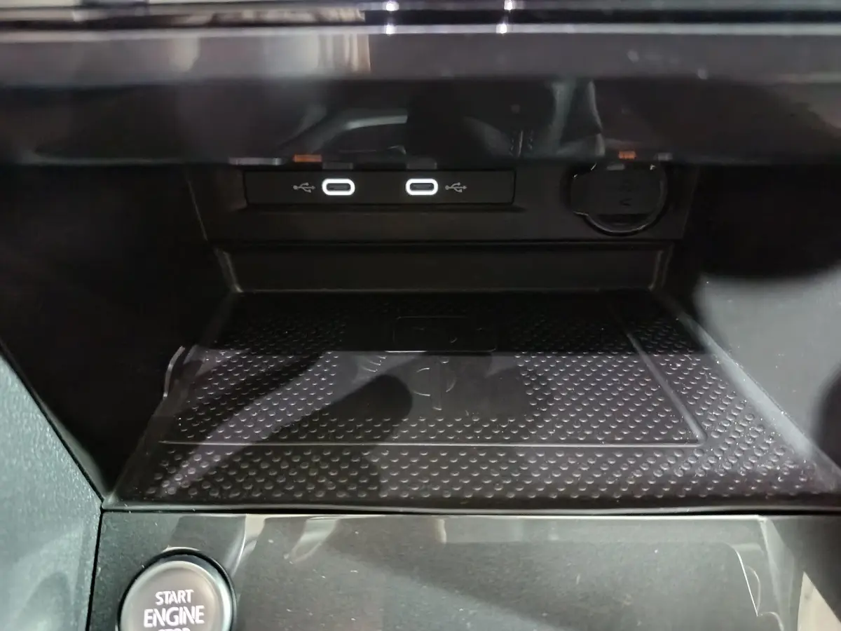 Gros plan sur la console centrale du Volkswagen Tiguan 2021, montrant ports USB, prise 12V et bouton démarrage.
