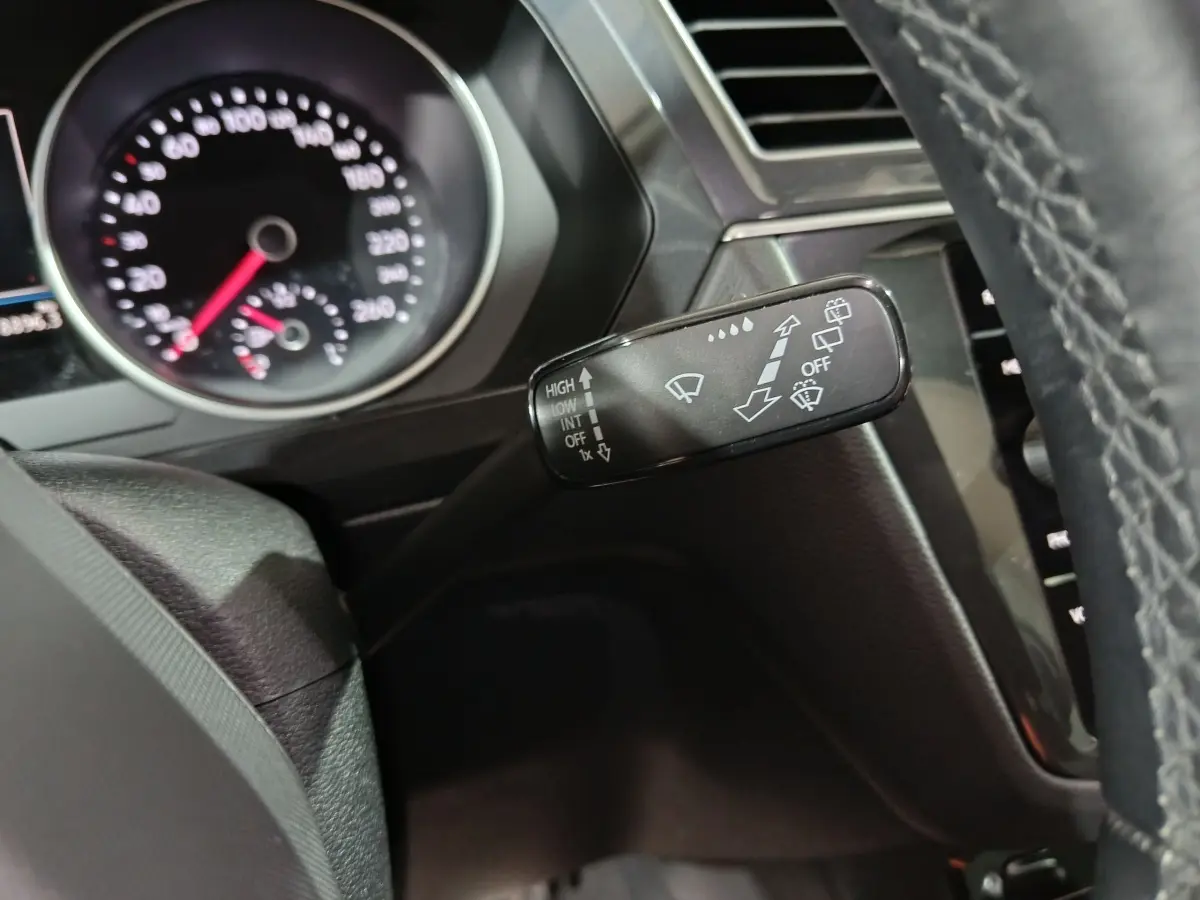 Gros plan sur la manette d’essuie-glace à gauche du volant cuir du Volkswagen Tiguan 1.5 TSI 2021.