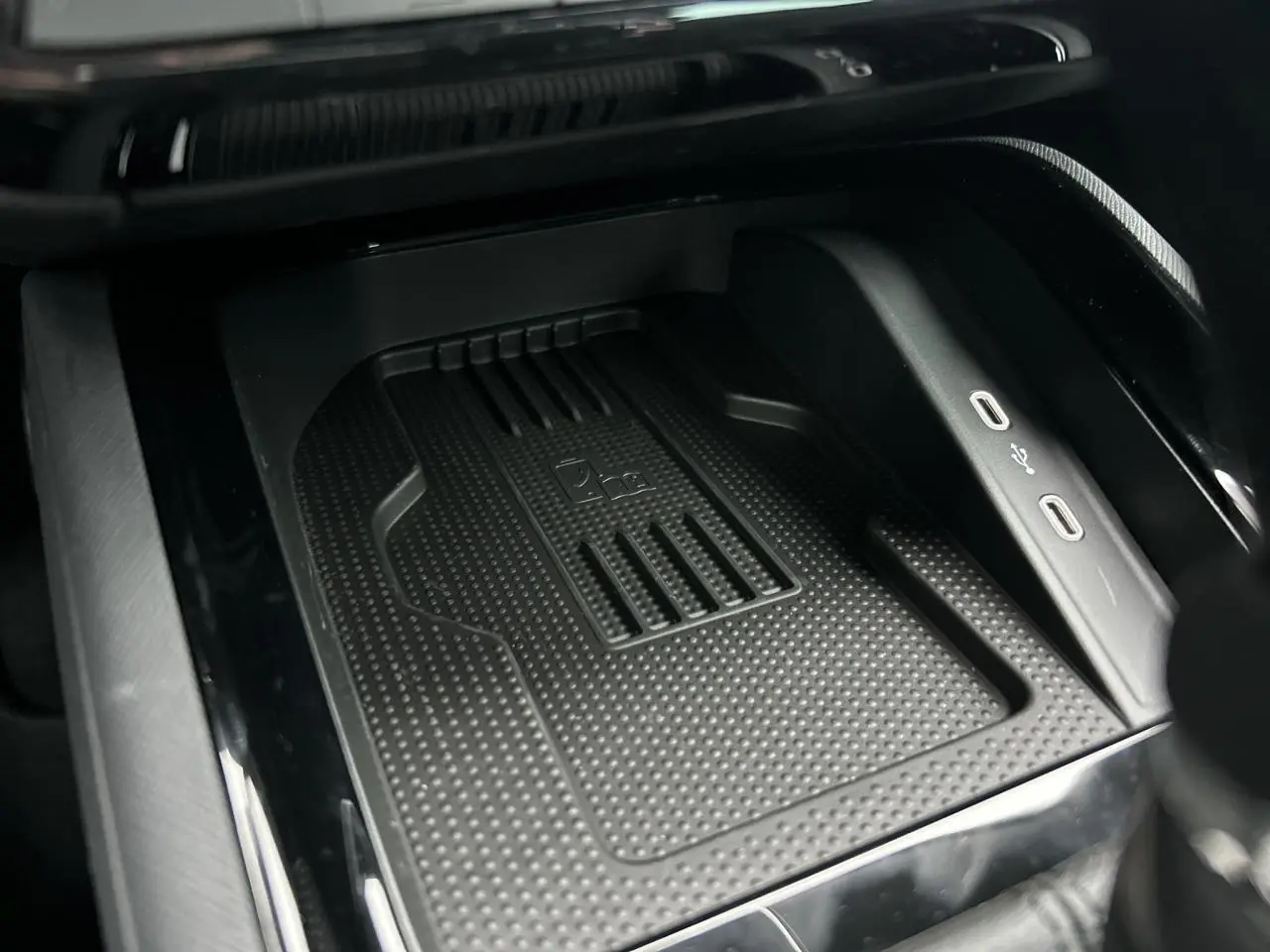 Gros plan sur le compartiment de charge à induction noir avec deux ports USB-C dans la console centrale du Skoda Kamiq 2025.