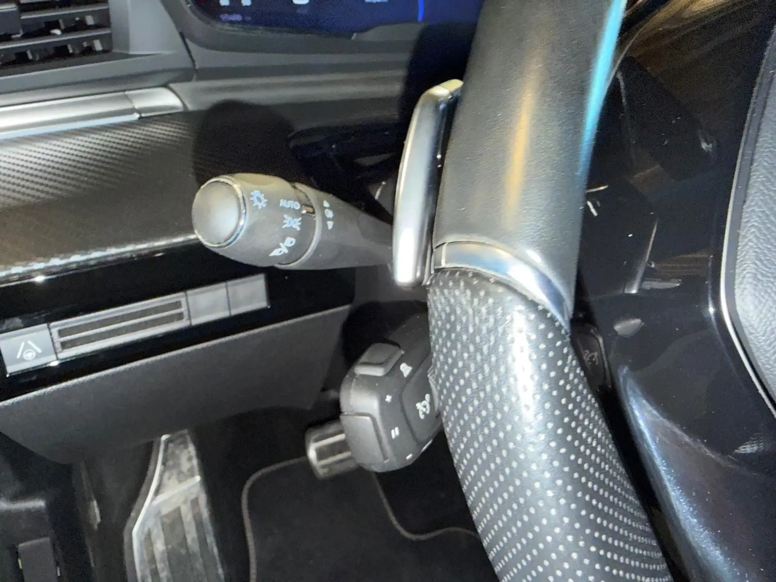 Gros plan sur le volant cuir perforé et les commandes derrière le volant du Peugeot 508 SW noir, intérieur noir Mistral.