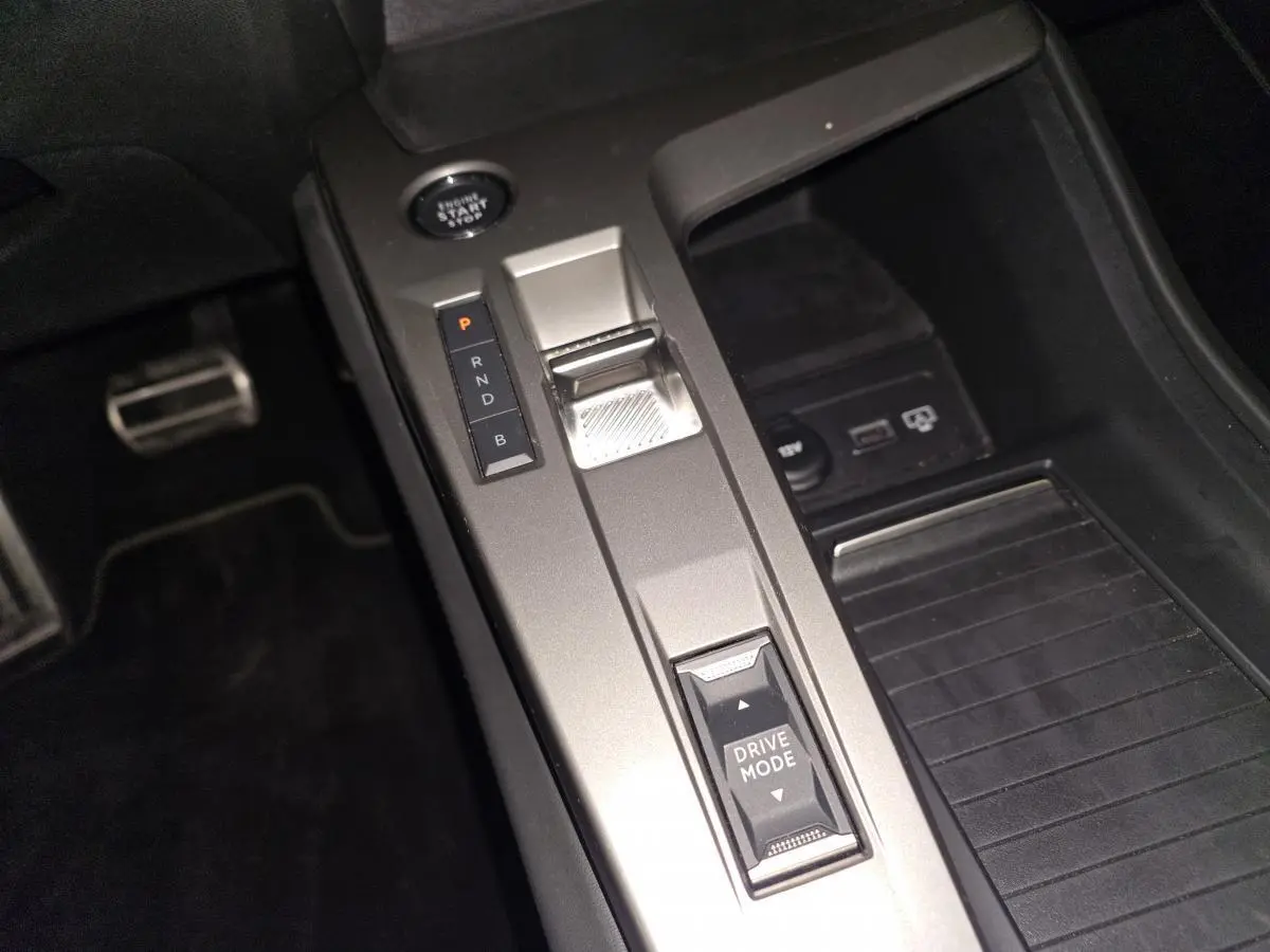 Gros plan sur la console centrale grise avec levier de vitesses électronique et bouton Drive Mode du Peugeot 408 2024.