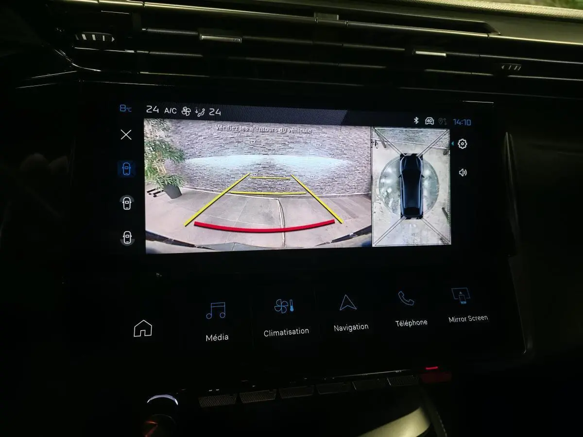 Écran tactile intérieur montrant la caméra de recul et la vue 360° du Peugeot 408 bleu, tableau de bord noir.
