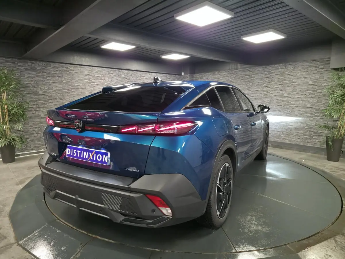 Vue 3/4 arrière droite d'une Peugeot 408 hybride rechargeable bleu métallisé avec feux arrière LED et jantes alliage 19 pouces.