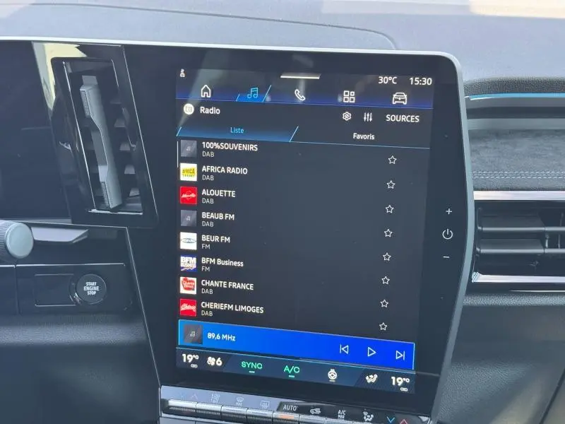 Écran tactile central du Renault Espace 2025 affichant la liste des radios, entouré de la console noire.