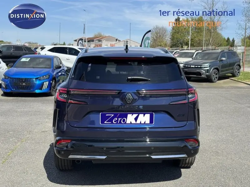 Vue arrière d'un Renault Espace 2025 bleu nocturne avec feux LED et logo distinctif sur un parking extérieur.