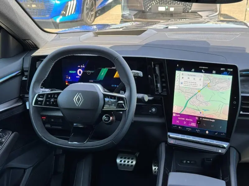 Vue intérieure frontale du tableau de bord du Renault Espace 2025 avec écran tactile vertical et volant multifonction noir.