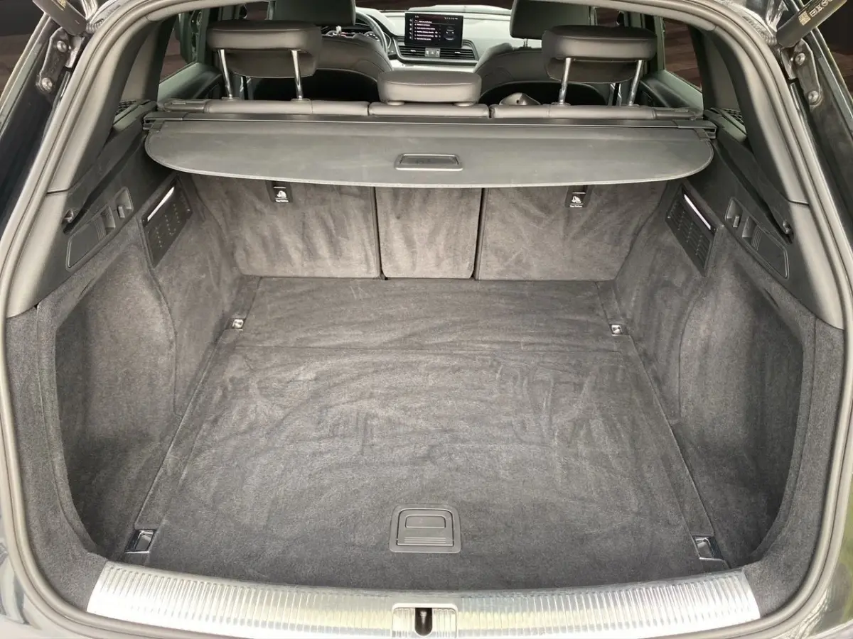 Coffre ouvert vu de l'arrière d'un Audi Q5 noir 35 TDI 2022, avec banquette arrière et cache-bagages visibles.