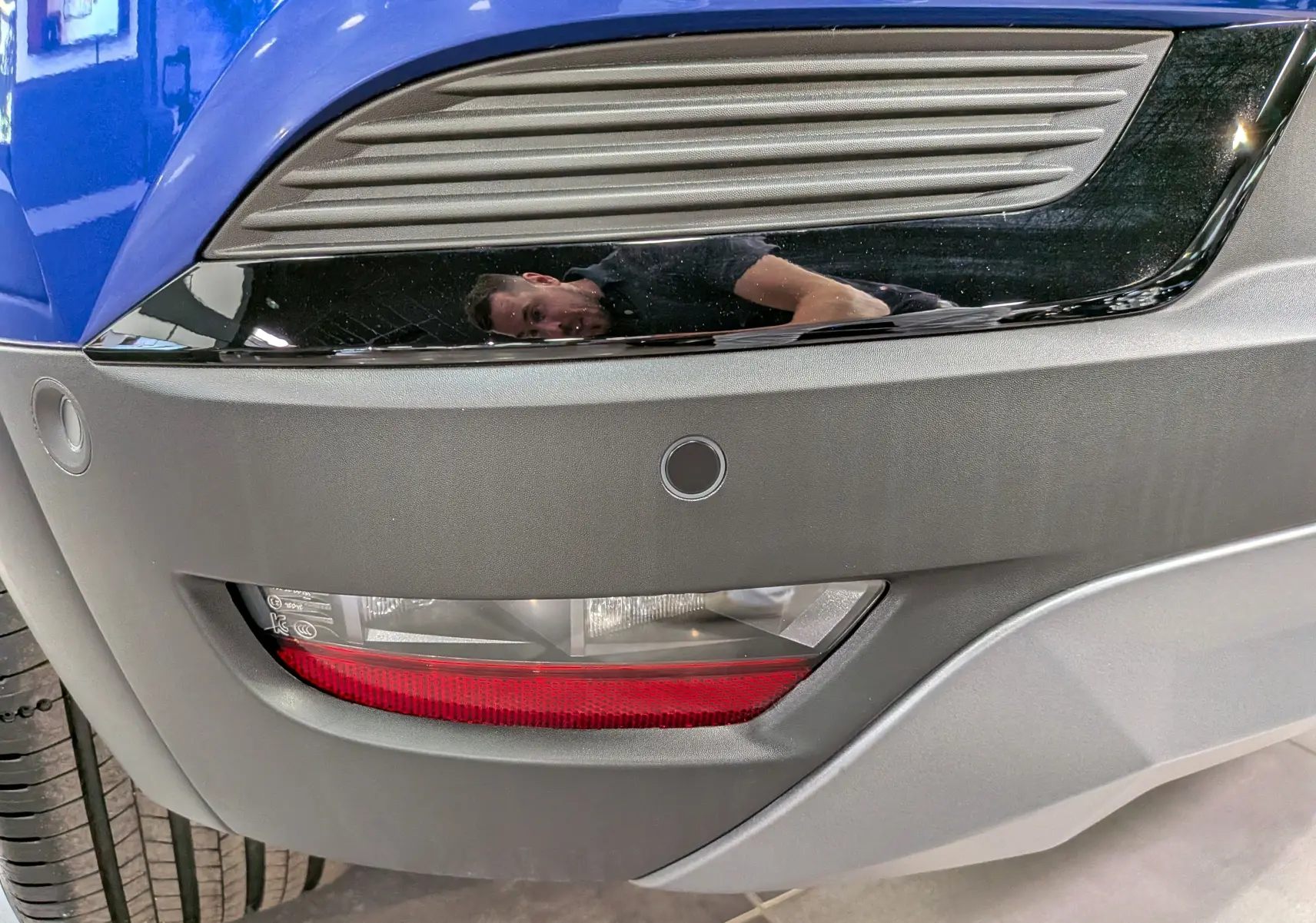 Gros plan sur le feu arrière droit et le pare-chocs gris du Renault Captur E-TECH bleu Iron avec toit noir.
