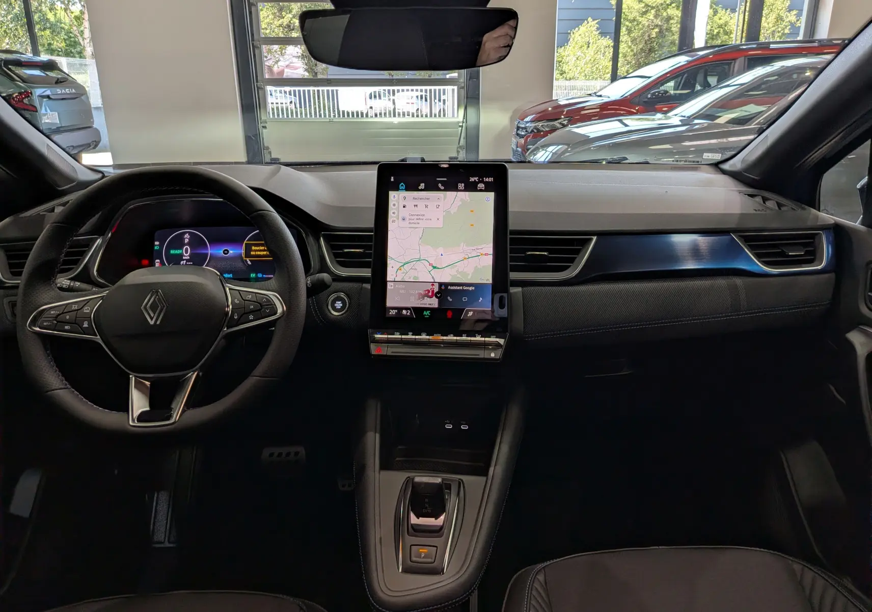 Vue intérieure avant du Renault Captur E-TECH 2026, tableau de bord noir avec écran tactile vertical et volant multifonction.