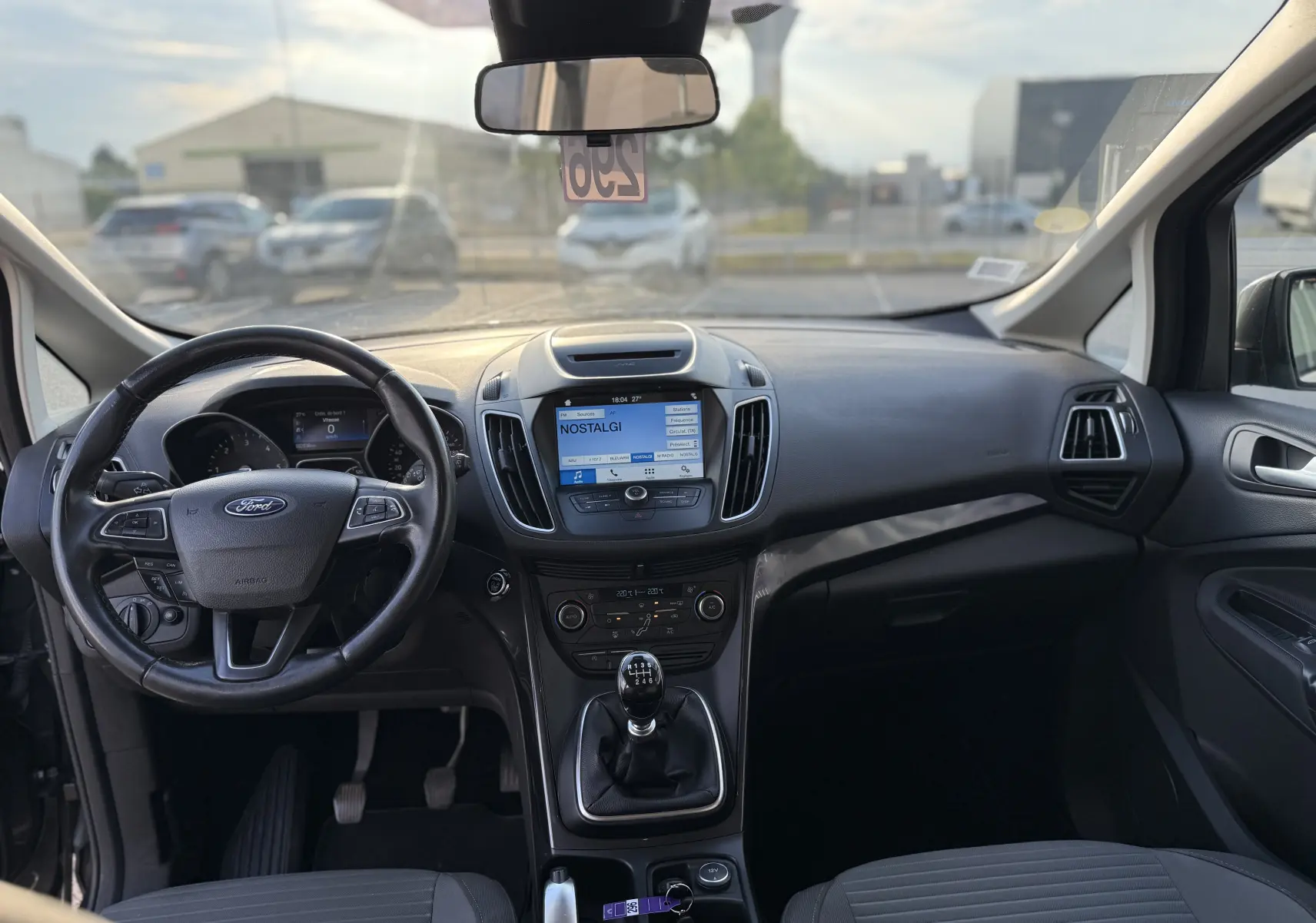 Vue intérieure avant du Ford C-MAX 1.6 TDCI 120 Titanium 2018, avec tableau de bord noir et écran tactile central.