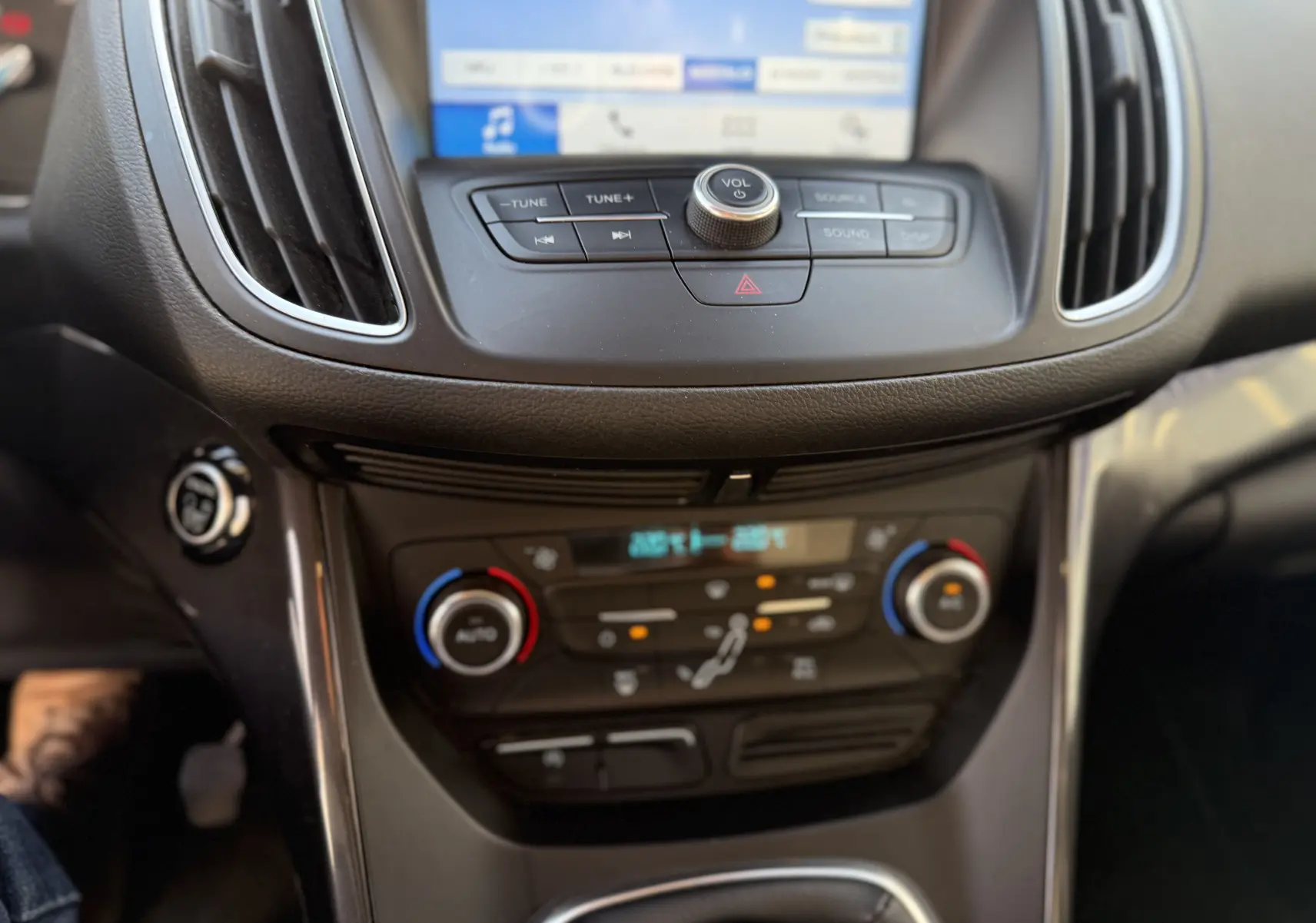 Gros plan sur la console centrale du Ford C-MAX 2018, montrant les commandes de climatisation et l’écran tactile.