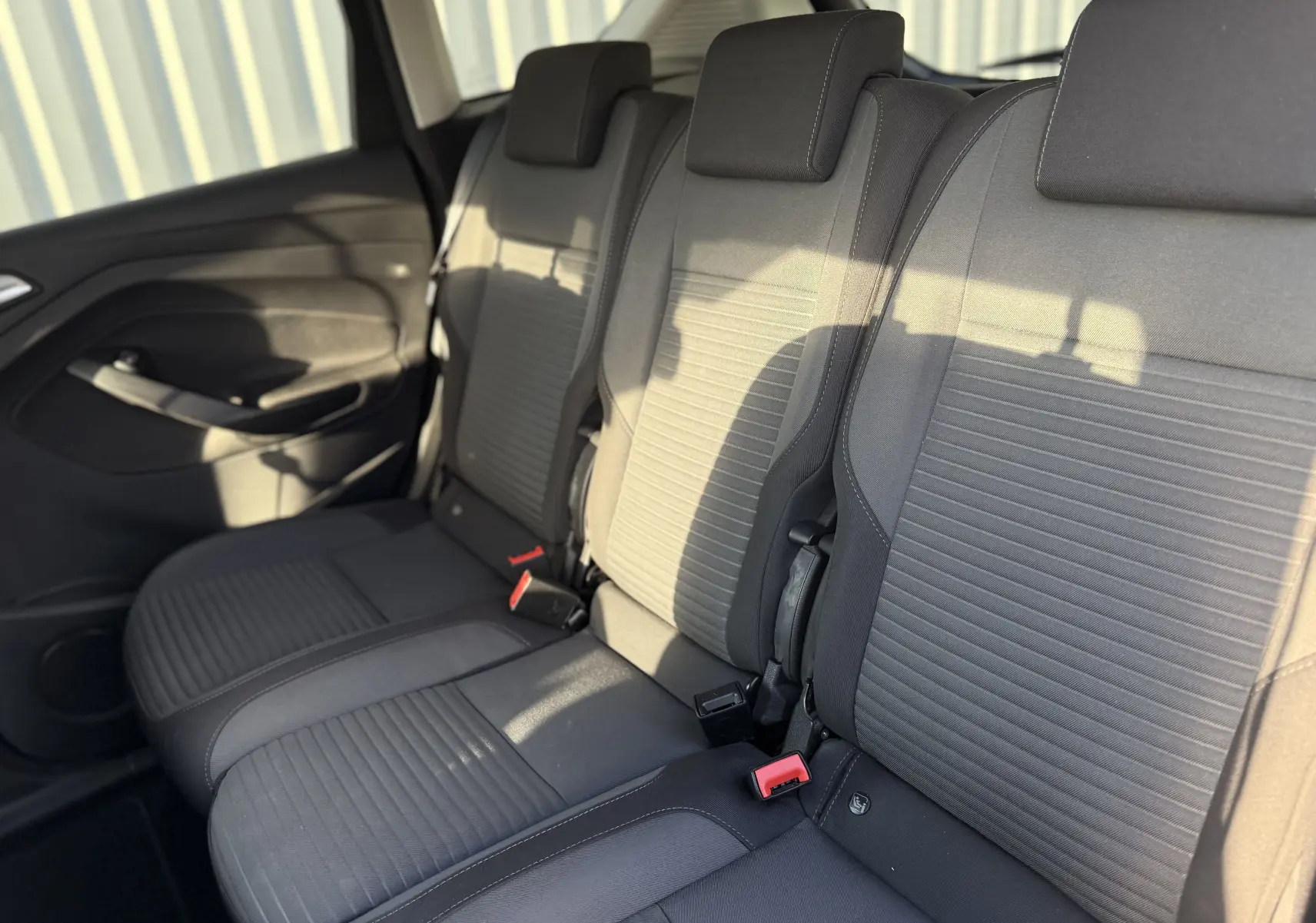 Vue intérieure des sièges arrière en tissu gris du Ford C-MAX 1.6 TDCI 120 Titanium, avec ceintures et appuie-têtes visibles.