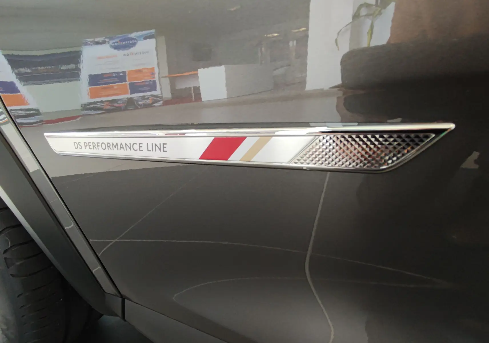 Détail de l'aile avant gauche gris métallisé du DS7 Crossback 2022 avec l’inscription DS Performance Line.