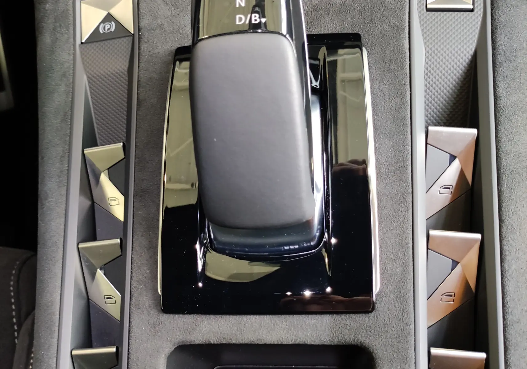 Gros plan sur la console centrale du DS7 Crossback gris 2022, mettant en valeur le levier de vitesses et les boutons de commande.