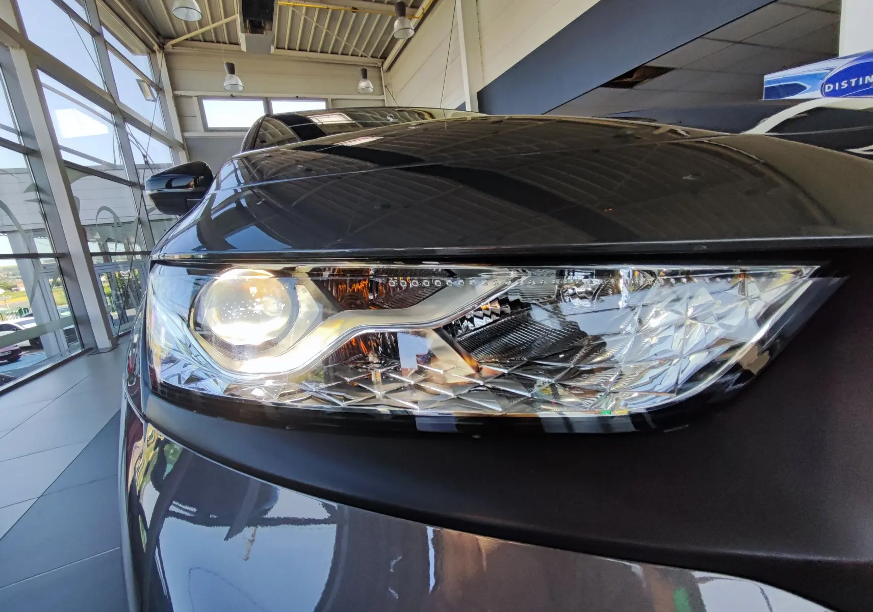 Gros plan sur le phare avant gauche du DS7 Crossback gris, mettant en valeur son design lumineux et ses détails facettés.