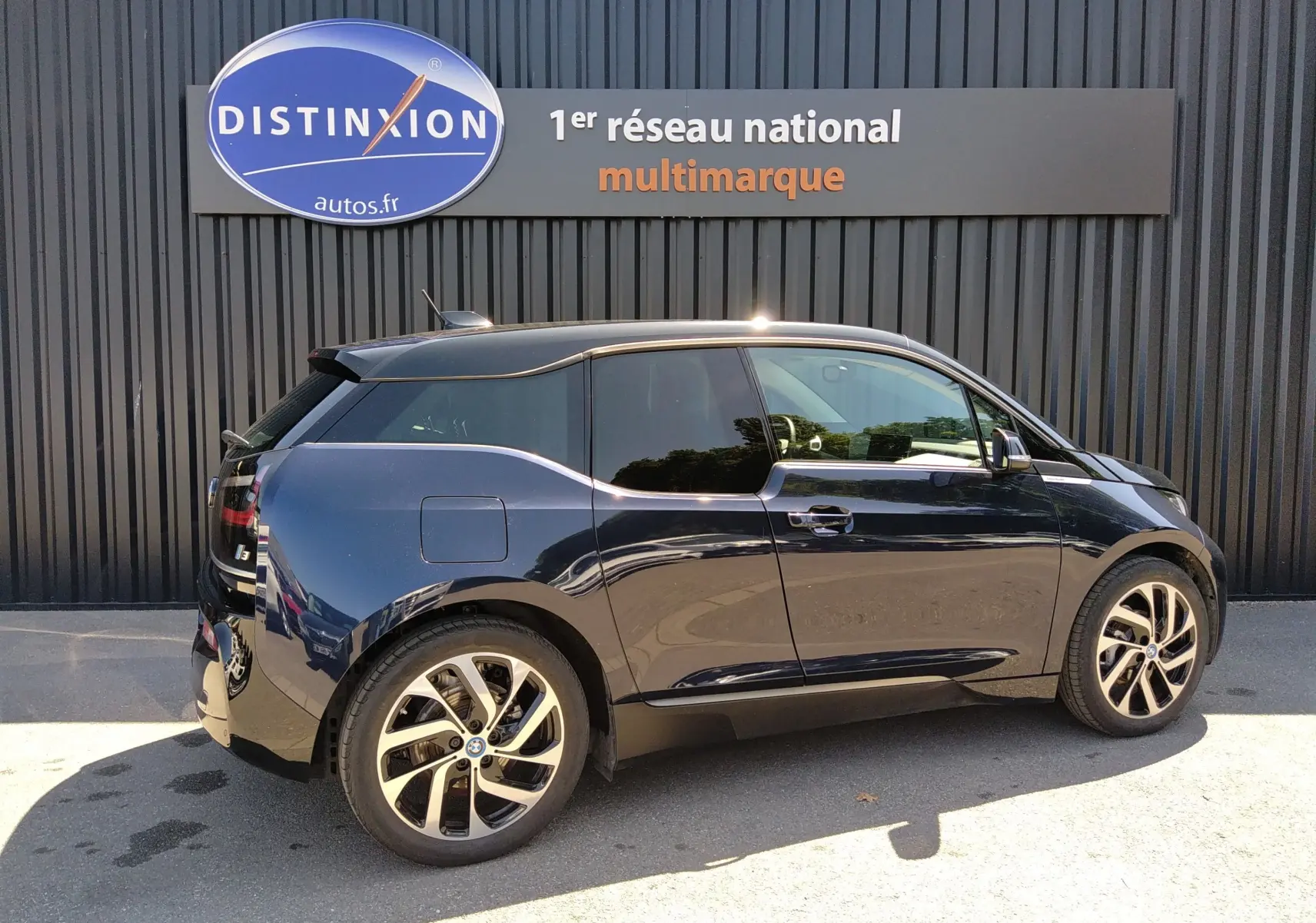 BMW i3 électrique bleu vue de profil côté gauche, mettant en valeur ses jantes modernes et sa silhouette compacte.