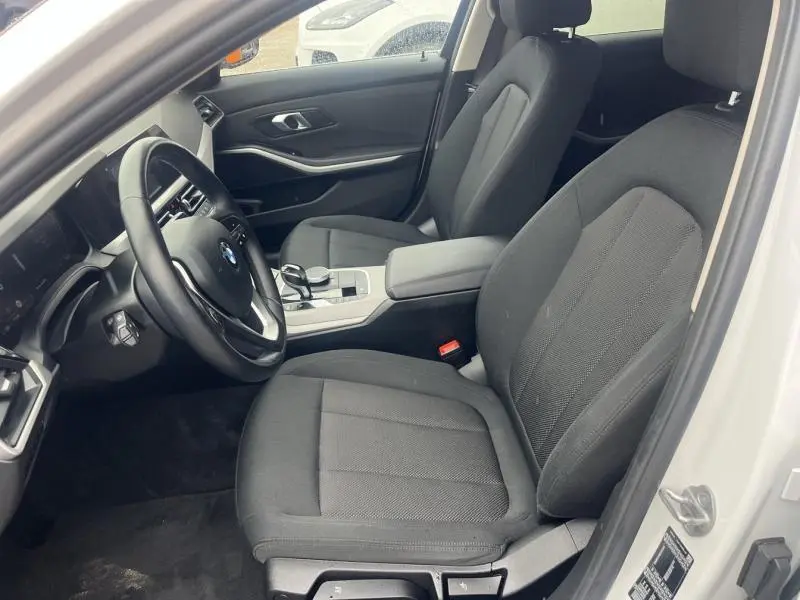 Vue intérieure côté conducteur d'une BMW Série 3 316dA 2021 avec sièges tissu noir et volant cuir multifonction