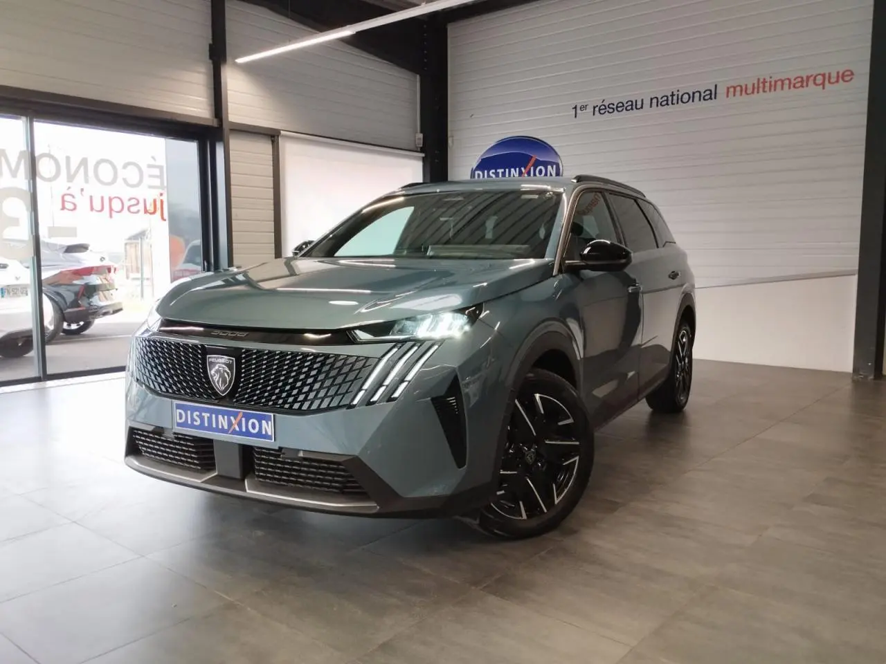 Peugeot 5008 Bleu Ingaro en 3/4 avant droit, avec calandre noire laquée et jantes alliage 19 pouces.