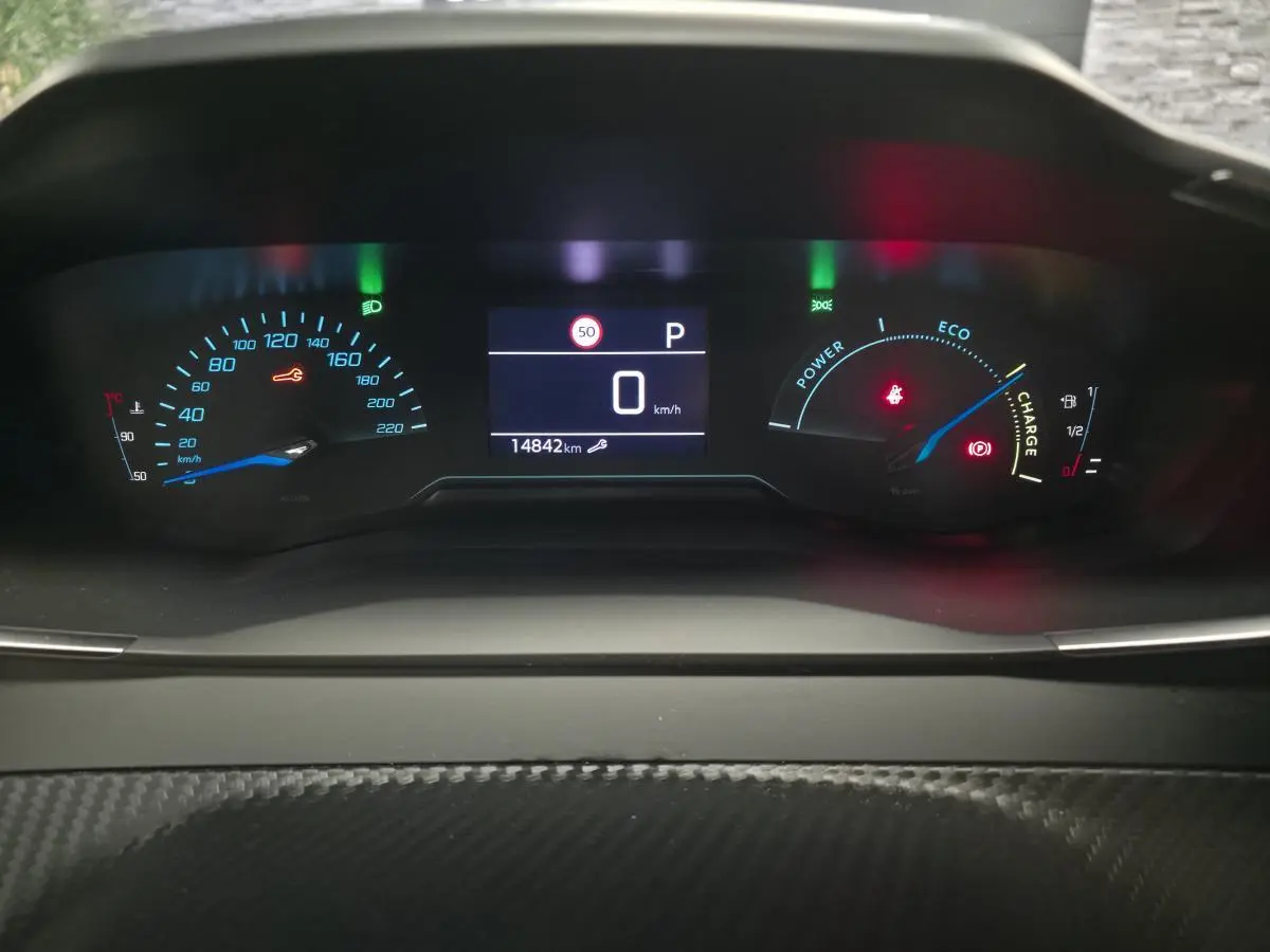 Vue rapprochée du combiné d'instruments numérique du Peugeot 2008 gris, affichant 0 km/h et 14842 km au compteur.