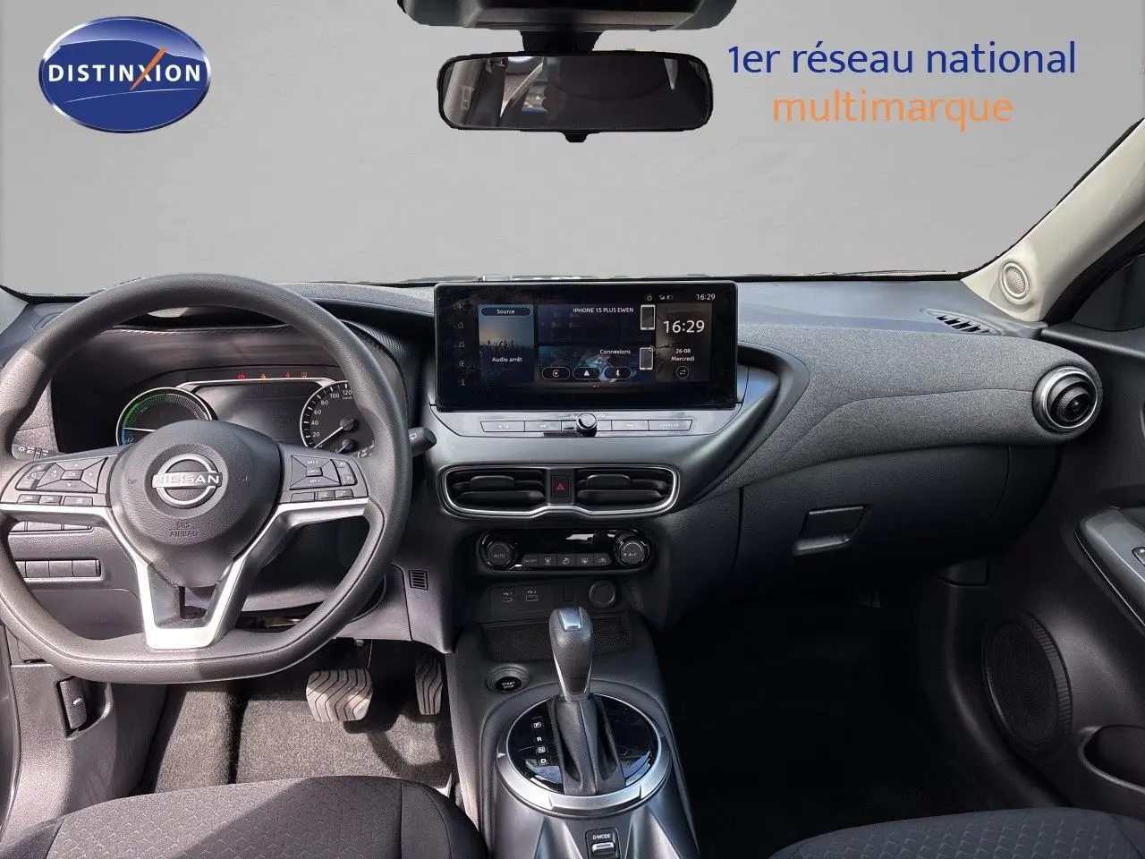 Vue intérieure avant du tableau de bord et volant du Nissan Juke Hybrid 2024 en finition Business Edition, intérieur noir.